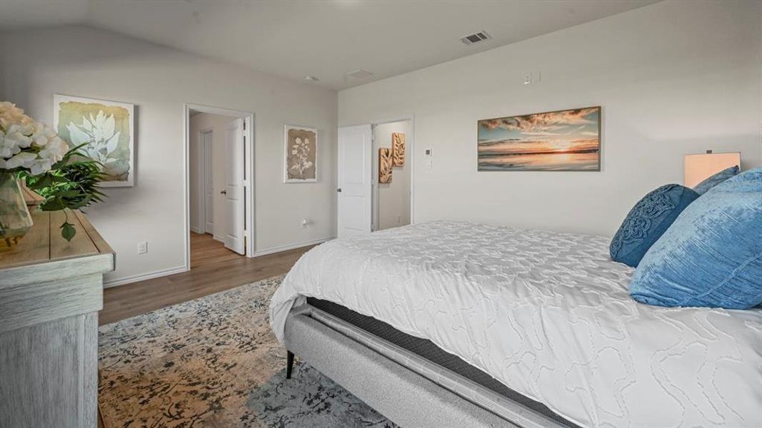 Bedroom featuring dark wood-type flooring and lofted ceiling