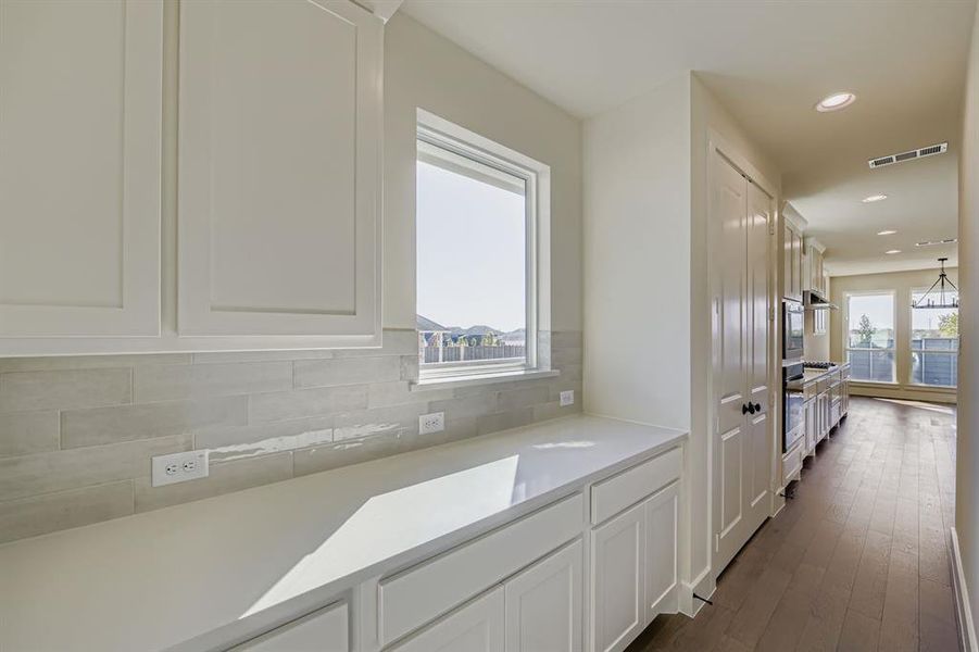 Kitchen with white cabinets, recessed lighting, tasteful backsplash, dark wood finished floors, and stainless steel oven