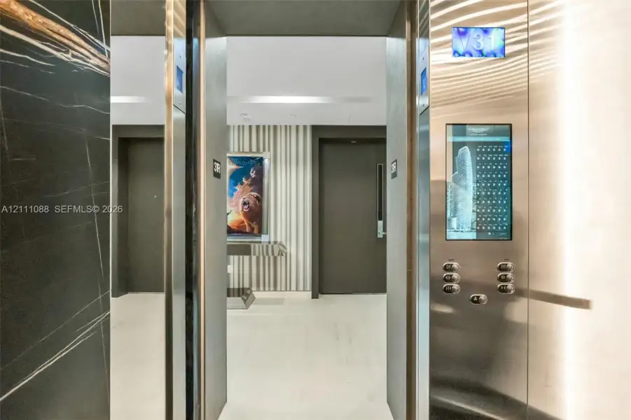 Elevator featuring brushed stainless steel finishes, a digital interface, and interior dark stone wall cladding Elevator featuring brushed stainless steel finishes, a digital interface, and interior dark stone wall cladding