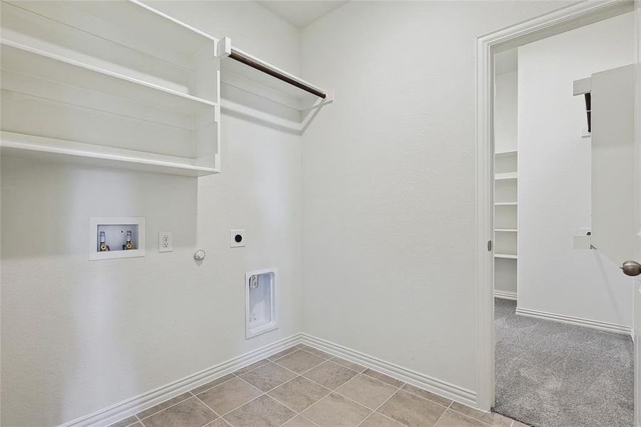 Clothes washing area with washer hookup, gas dryer hookup, light colored carpet, and hookup for an electric dryer