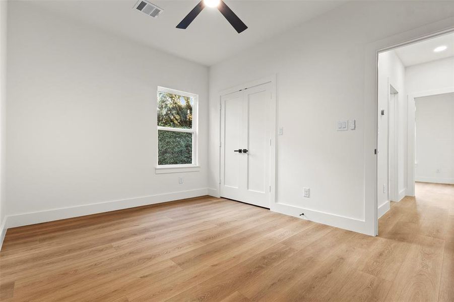 Unfurnished bedroom featuring light wood-style flooring, a ceiling fan, and a closet