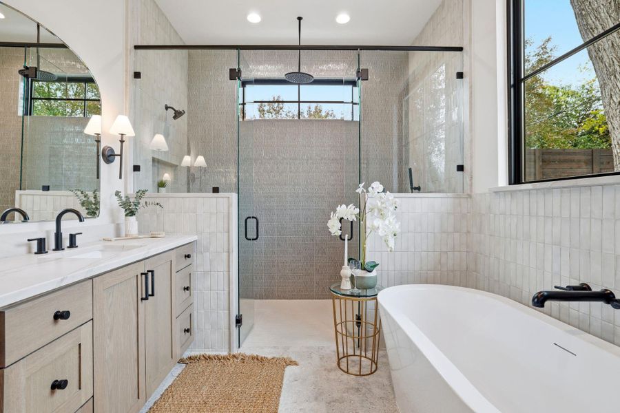 Full bathroom with a soaking tub, vanity, tile walls, a shower stall, and healthy amount of natural light