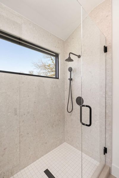 Bathroom with a shower stall and vaulted ceiling
