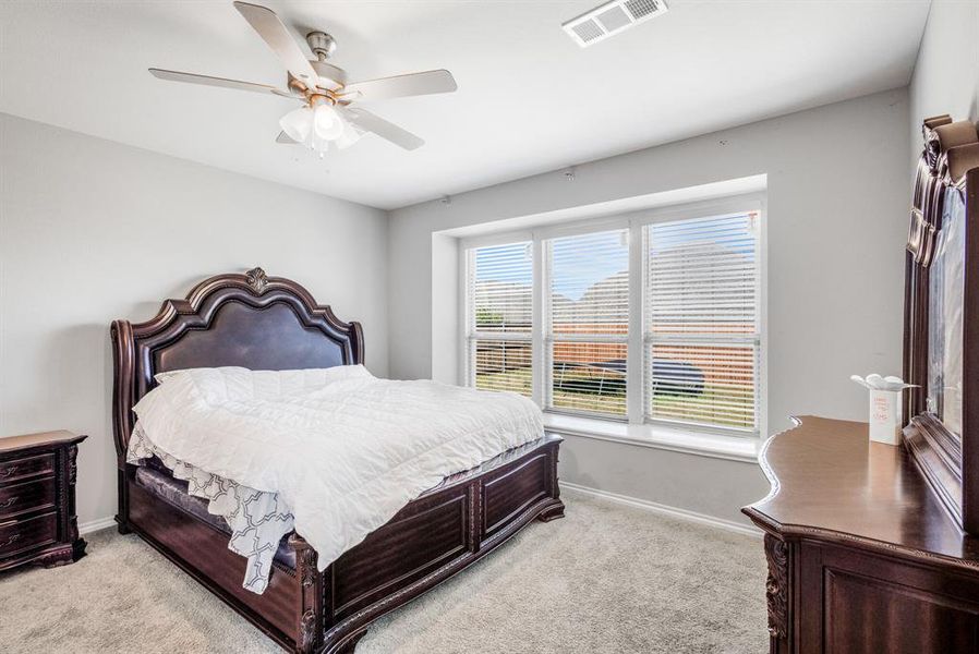 Bedroom with light colored carpet and a ceiling fan Bedroom with light colored carpet and a ceiling fan