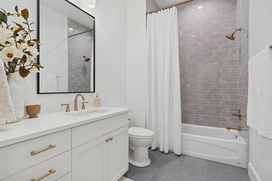 Incredible hallway bathroom with the same perfect finishes: porcelain tile, champagne fixtures, custom cabinets and tons of storage. No detail missed!