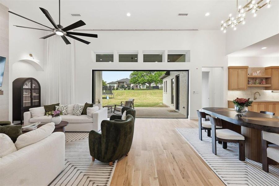 Living room featuring a high ceiling, light wood-style floors, recessed lighting, and arched walkways