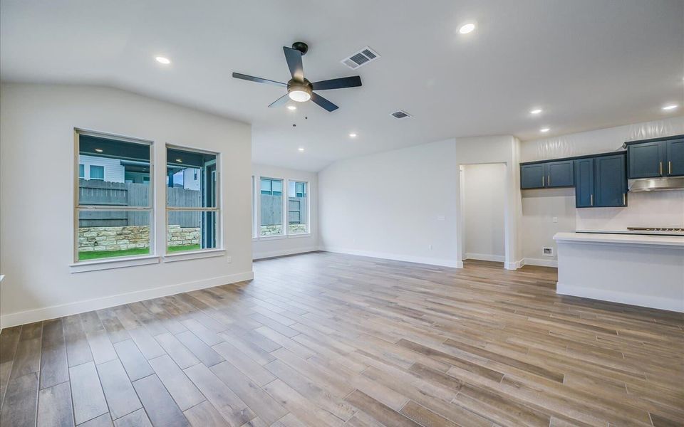 An inviting open-concept living space features wood-look tile flooring and abundant natural light. An inviting open-concept living space features wood-look tile flooring and abundant natural light.