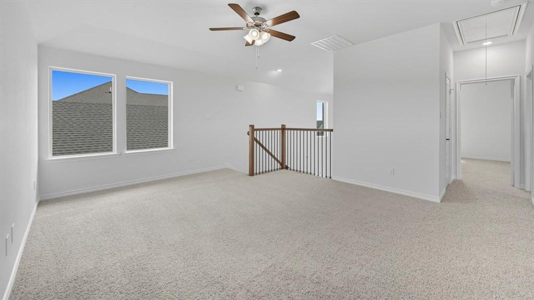 Spare room featuring attic access, a ceiling fan, and light carpet Spare room featuring attic access, a ceiling fan, and light carpet