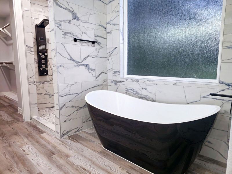 Primary bathroom with a modern freestanding bathtub.