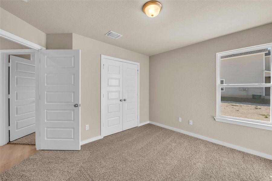 Unfurnished bedroom with a closet, light carpet, and a textured ceiling