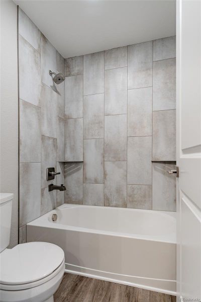 tub to ceiling tile with built in shower shelves and designer fixtures