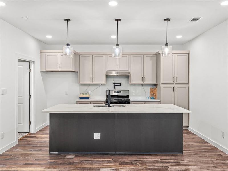 Kitchen with pendant lighting, recessed lighting, dark wood-style flooring, and gas stove