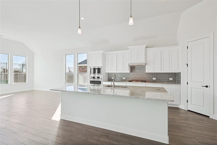 Kitchen with stainless steel appliances, sink, pendant lighting, and a wealth of natural light