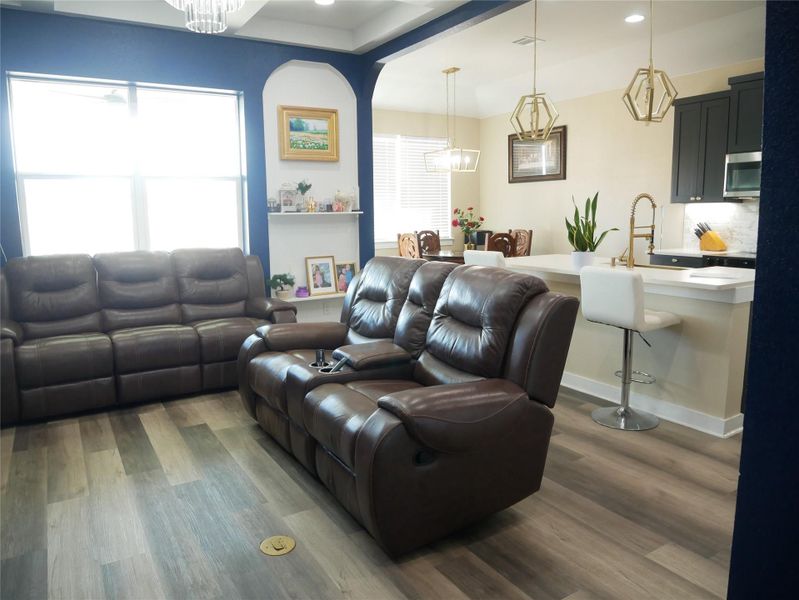 Living area featuring dark wood-type flooring and a chandelier