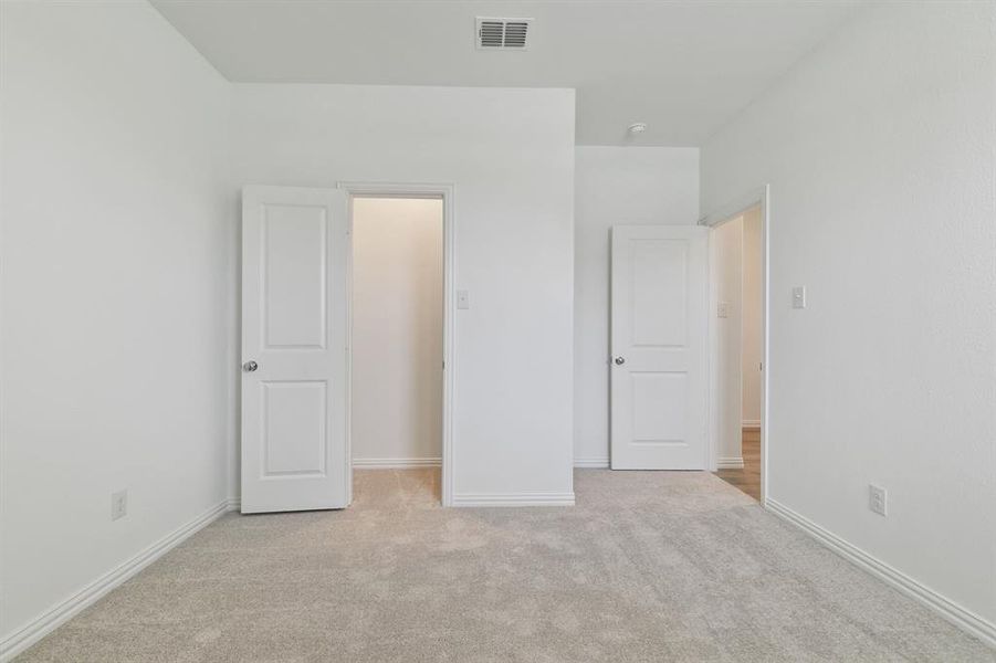Unfurnished bedroom featuring light colored carpet