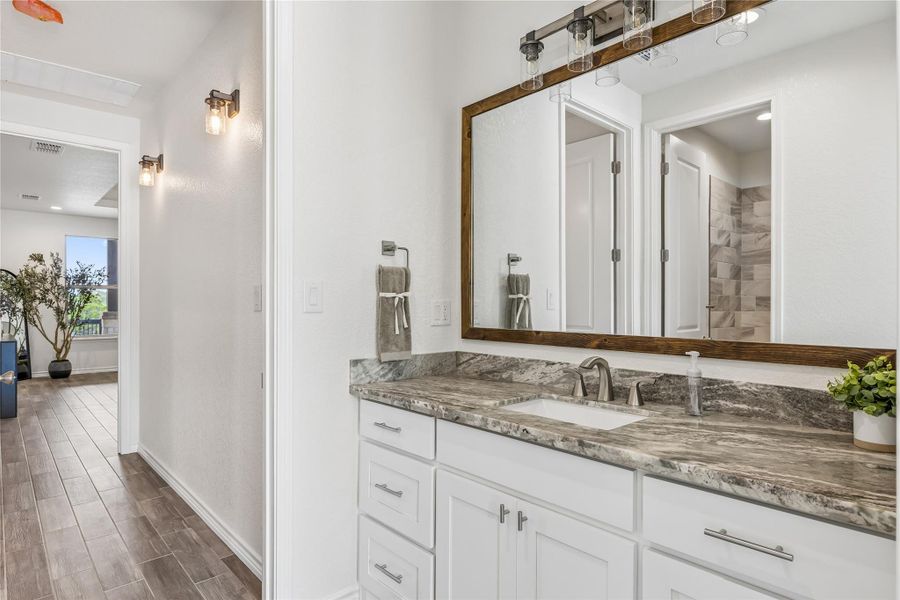 A well-appointed bathroom vanity features a broad mirror and sleek countertops.