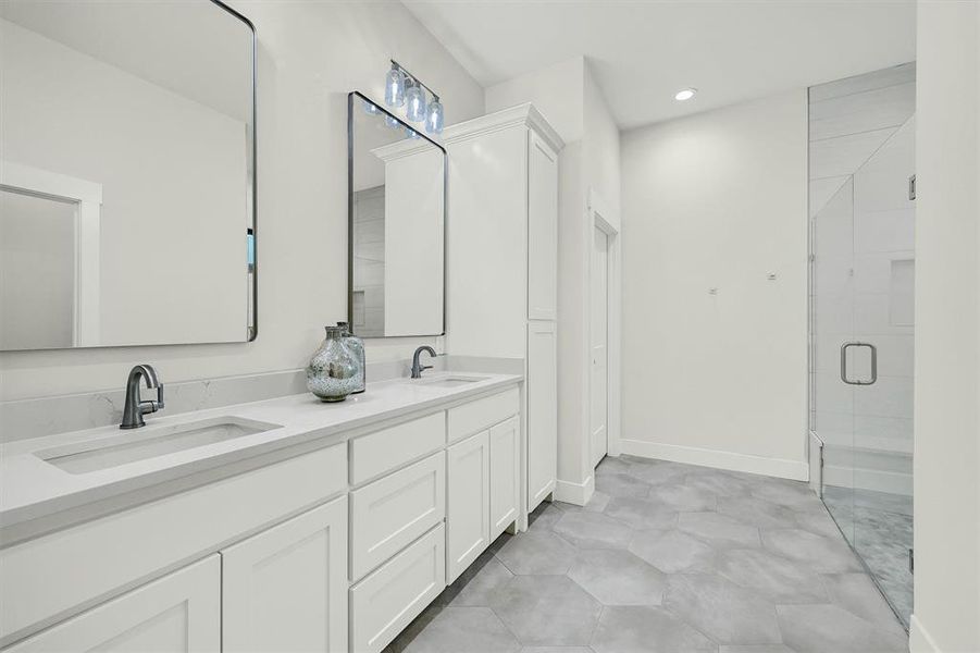 Bathroom featuring dual bowl vanity, walk in shower, and tile patterned floors