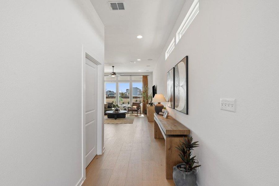 Long hallway featuring wood-finish flooring and recessed lighting