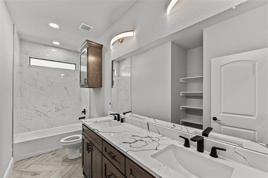Full bathroom featuring double vanity, bathing tub / shower combination, and recessed lighting Full bathroom featuring double vanity, bathing tub / shower combination, and recessed lighting