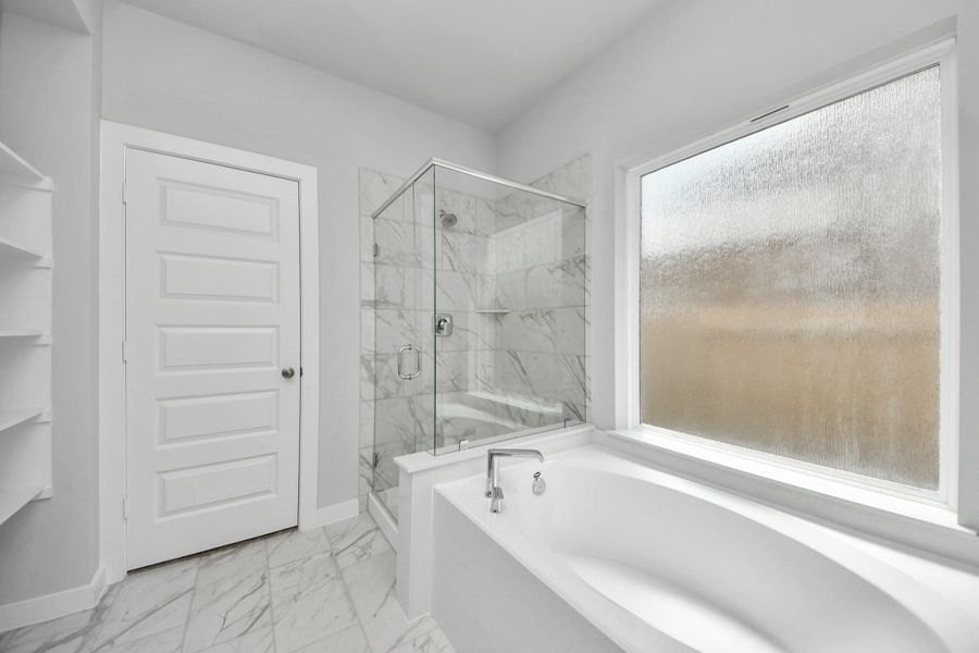 Indulge in a spa-like retreat within the confines of this primary bathroom. Sample photo of completed home with similar floor plan. Actual colors and selections may vary.