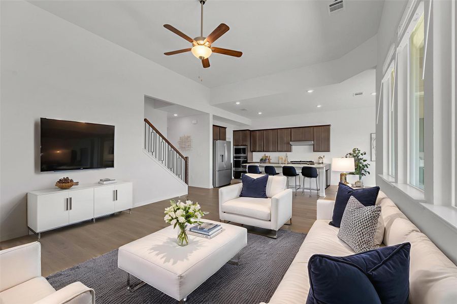 Living room featuring light wood-type flooring, a ceiling fan, recessed lighting, and stairway Living room featuring light wood-type flooring, a ceiling fan, recessed lighting, and stairway