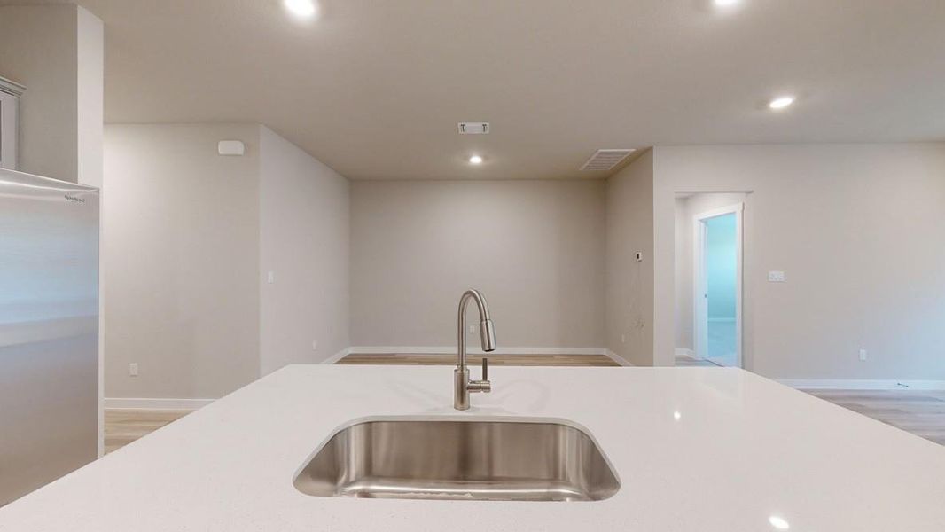 Kitchen featuring stainless steel refrigerator, light wood-style flooring, recessed lighting, and light stone countertops