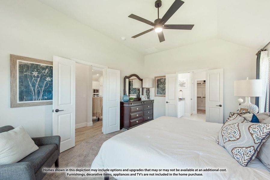 Master bedroom with vaulted ceiling, ceiling fan, and doors leading to ensuite bathroom and walk-in closet