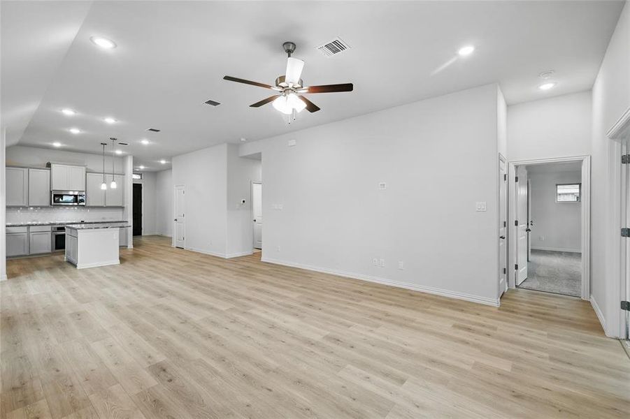 Unfurnished living room featuring recessed lighting, ceiling fan, light wood finished floors, and vaulted ceiling