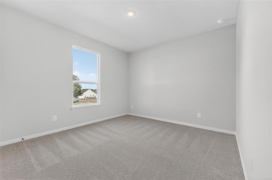 Spare room with light carpet and baseboards Spare room with light carpet and baseboards