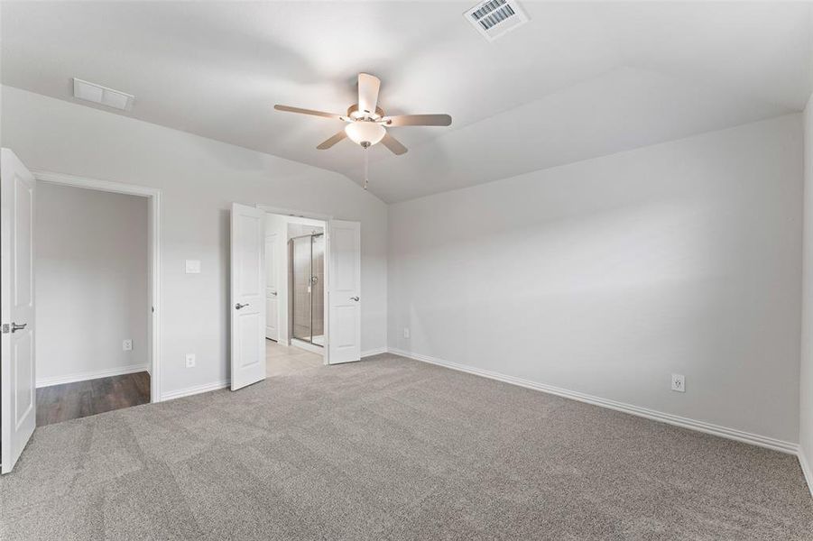 Unfurnished bedroom featuring carpet floors, lofted ceiling, and ceiling fan Unfurnished bedroom featuring carpet floors, lofted ceiling, and ceiling fan