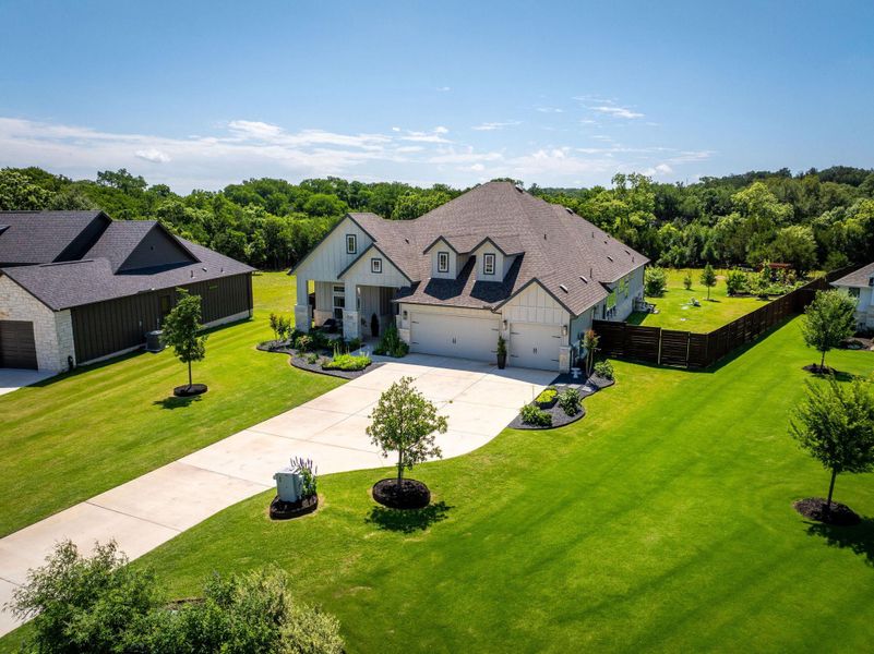 A well-maintained lawn and extended driveway welcome visitors to this charming residence, nestled amidst lush greenery.