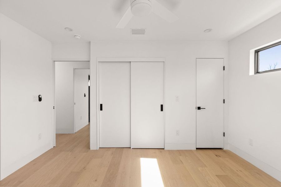 Unfurnished bedroom featuring light wood-style flooring, ceiling fan, and a closet