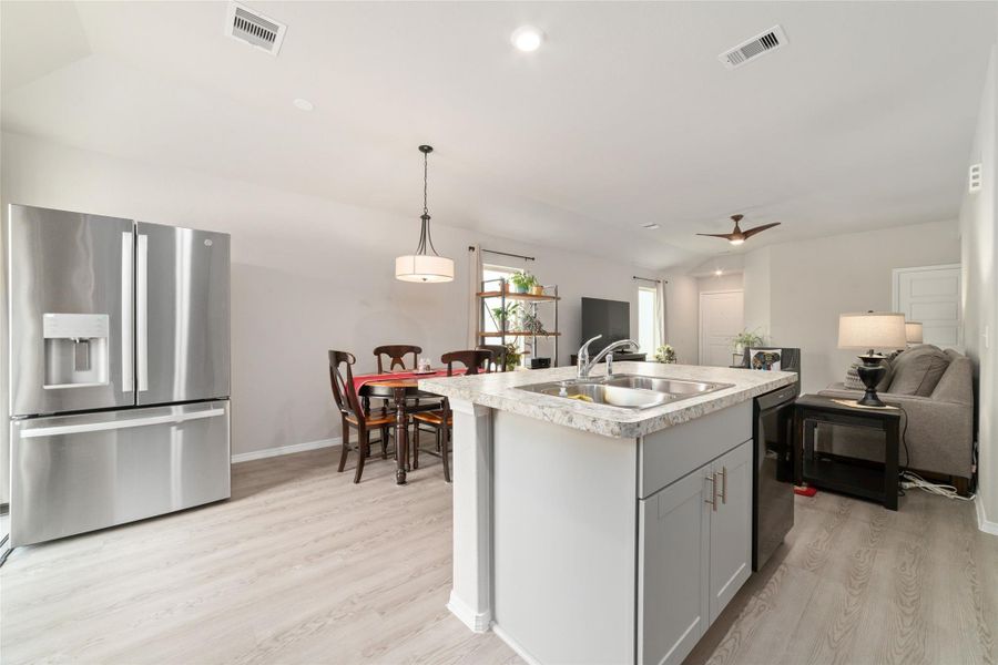 View from the kitchen showcasing the open layout, with high ceilings and natural light carrying through to the living and dining areas for a connected feel.