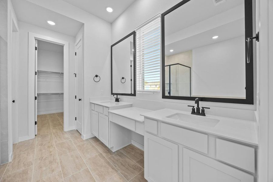 Full bath with a shower stall, vanity, recessed lighting, and a walk in closet Full bath with a shower stall, vanity, recessed lighting, and a walk in closet
