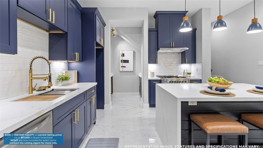 Cooking feels effortless with the sleek navy cabinetry, gold fixtures, and plenty of counter space to spread out and create.