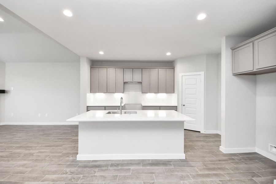 This generously spacious kitchen is a dream realized! With a massive granite island, high ceilings, soft close cabinets, granite countertops, stainless steel appliances, a sleek tile backsplash, recessed lighting, and an extended counter area, it offers both style and practicality. All this opens up to the expansive family room, creating a perfect hub for gatherings. This generously spacious kitchen is a dream realized! With a massive granite island, high ceilings, soft close cabinets, granite countertops, stainless steel appliances, a sleek tile backsplash, recessed lighting, and an extended counter area, it offers both style and practicality. All this opens up to the expansive family room, creating a perfect hub for gatherings.