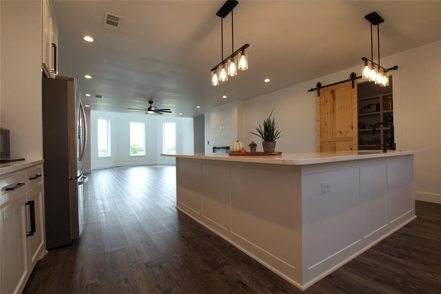 Kitchen with a barn door, pendant lighting, freestanding refrigerator, recessed lighting, and a ceiling fan Kitchen with a barn door, pendant lighting, freestanding refrigerator, recessed lighting, and a ceiling fan