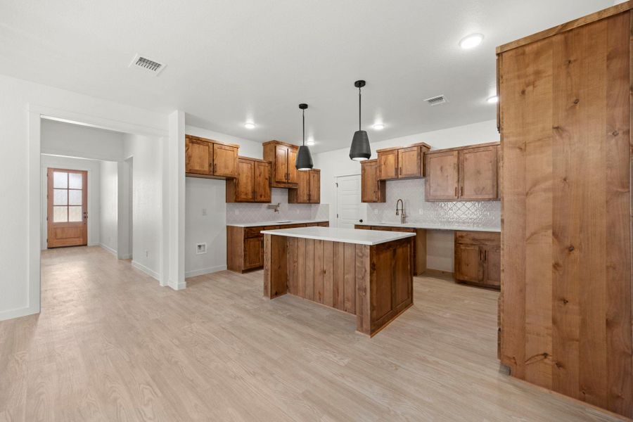 A well-appointed kitchen features a large island and ample cabinetry, offering both functionality and inviting warmth.