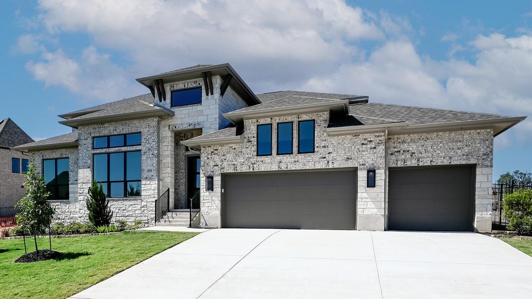 View of front of home with roof with shingles, concrete driveway, brick siding, an attached garage, and stone siding View of front of home with roof with shingles, concrete driveway, brick siding, an attached garage, and stone siding