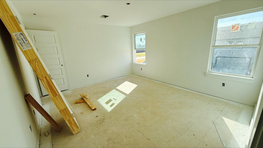 Natural sunshine spills through the windows of this generously-sized main bedroom!