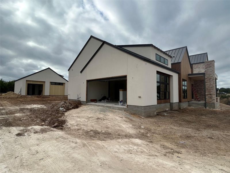 View of side of home featuring a standing seam roof, a metal roof, and a patio View of side of home featuring a standing seam roof, a metal roof, and a patio