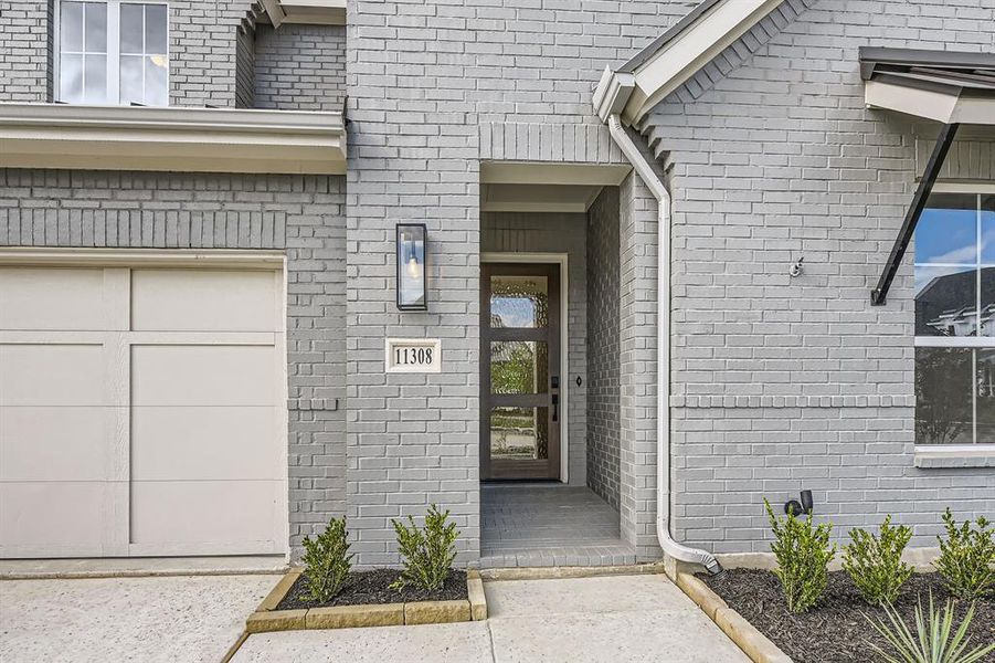Doorway to property with brick siding and an attached garage Doorway to property with brick siding and an attached garage
