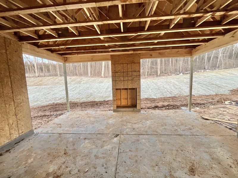 Extra large covered back porch with wood burning fireplace looking out onto protected woodlands.