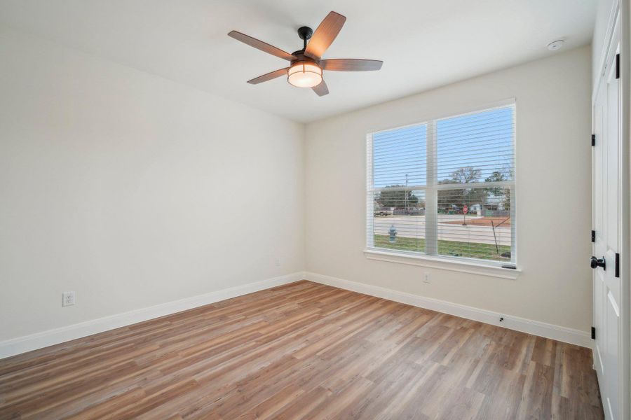 Bedroom 2 with light wood-style flooring, a ceiling fan, and baseboards