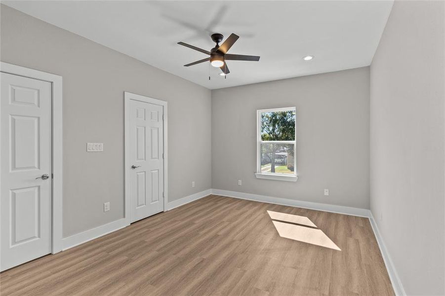 Another angle of the primary bedroom reveals two closet doors, providing ample storage space.