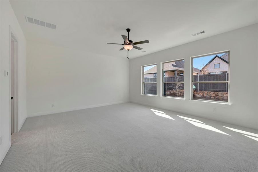 Unfurnished room featuring light colored carpet and ceiling fan