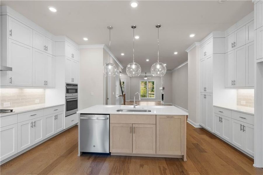 Kitchen with backsplash, white cabinetry, stainless steel appliances, recessed lighting, and dark wood-style flooring