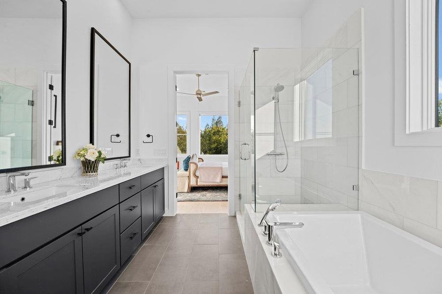 Ensuite bathroom featuring a bath, double vanity, a stall shower, tile patterned floors, and a ceiling fan