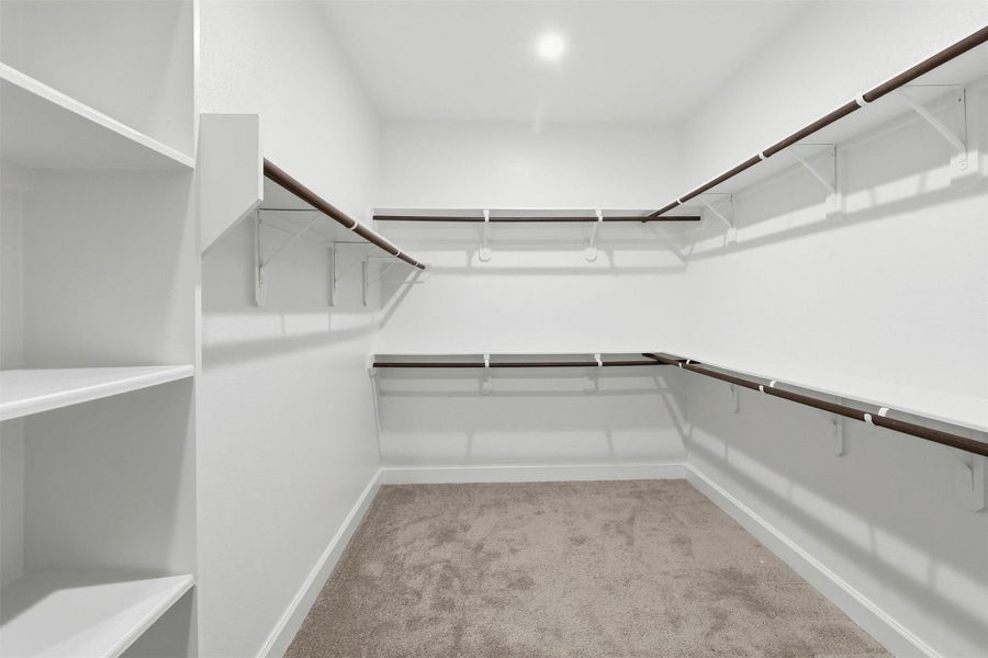The impressive walk-in closet offers exceptional storage with wraparound hanging space, built-in shelving, and room to easily organize clothing, shoes, and accessories while keeping everything within reach.
