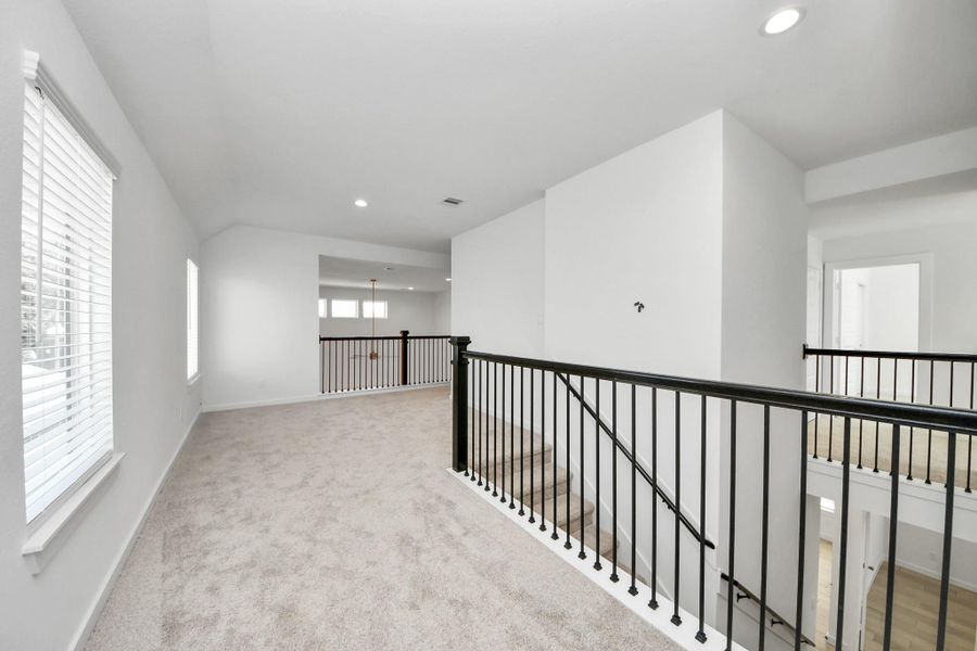 Come upstairs and enjoy a day of leisure in this fabulous game room! This is the perfect hangout spot or adult game room! Features plush carpet, high ceilings, custom paint and windows for plenty of natural light. Sample photo of completed home with similar floor plan. Actual colors and selections may vary.